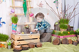 Beautiful funny little boy playing among easter spring scenery.