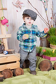 Beautiful funny little boy playing among easter spring scenery.