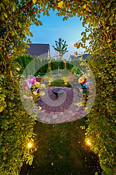 Beautiful garden with stone circle and fire bowl in the evening darkness with solar lamps in the ground