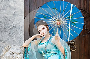 Beautiful geisha with a blue umbrella