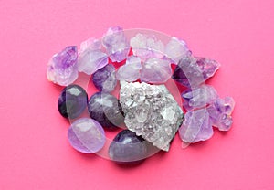 Beautiful gemstones,  geode of  amethyst and druses of natural purple mineral amethyst on a bright pink background. Amethysts and
