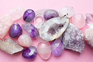 Beautiful gemstones,  geode amethyst and druses of natural purple mineral amethyst on a pink background. Amethysts and rose quartz