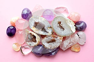 Beautiful gemstones,  geode amethyst and druses of natural purple mineral amethyst on a pink background. Amethysts and rose quartz