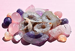 Beautiful gemstones,  geode amethyst and druses of natural purple mineral amethyst on a pink background. Amethysts and rose quartz