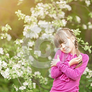 Beautiful gentle girl standing in a lush garden