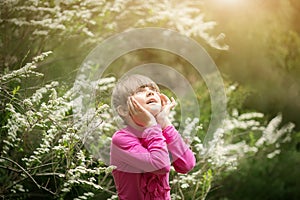 Beautiful gentle girl standing in a lush garden