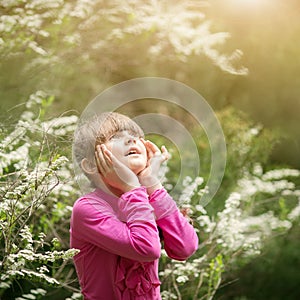 Beautiful gentle girl standing in a lush garden