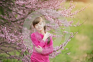 Beautiful gentle girl standing in a lush garden