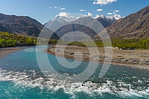 Beautiful Ghizer river, blue river surrounded by Hindu Gush mountains range in blossom season, Gilgit Baltistan, northern Pakistan