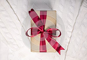 Beautiful gift box with red bow knot on white sweater