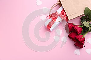 Beautiful gift box, roses and hearts on pink background, flat lay with space for text. Valentine`s day celebration