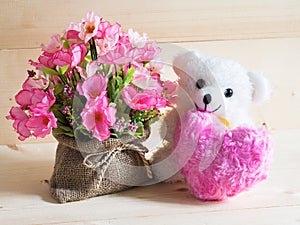 A beautiful gift with lovely bear and nice flowers on wooden background