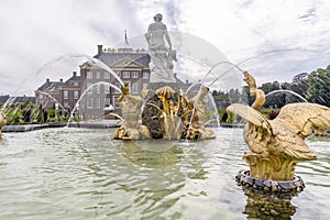 Beautiful gilded ornaments spray water upwards in a fountain in front of Paleis Het Loo in Apeldoorn, Netherlands