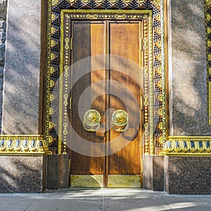 Gilding and monumental tree. entrance, gates, doors to a Buddhist temple. the concept of reliable protection