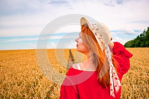 Beautiful ginger girl in wheat field