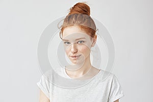 Beautiful ginger model with trendy bun biting lip.