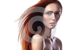 Beautiful ginger young woman with flying hair and naturel makeup. Beauty portrait of model with straight red hair