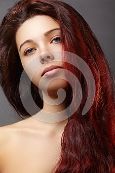 Beautiful ginger young woman with luxury hair style and fashion gloss makeup. Beauty closeup model with red hair