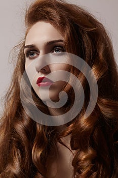 Beautiful ginger young woman with luxury hair style and fashion gloss makeup. Beauty closeup model with red hair