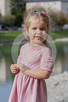 Beautiful girl 4-5 years old with blond long hair against the backdrop of a tourist landscape, old European architecture.