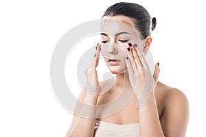 beautiful girl applying foundation cream on face