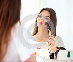 Beautiful girl applying makeup