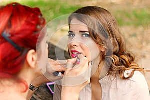 Beautiful girl applying makeup
