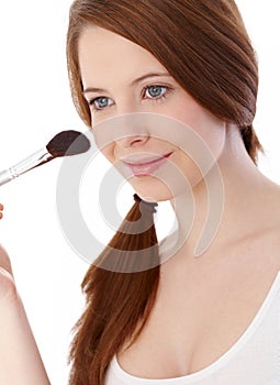 Beautiful girl applying makeup smiling