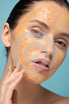 Beautiful girl applying yellow sugar scrub