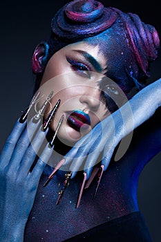 Beautiful girl with art fashion make up, creative hairstyle, long nails. Design manicure. Beauty face.