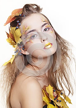 Beautiful girl with autumn make up and leaves on head