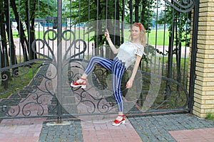 beautiful girl on the background of iron gates
