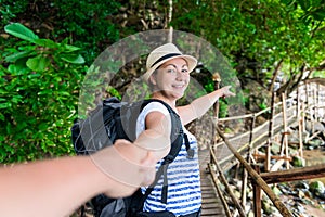 Beautiful girl with a backpack pulls her companion