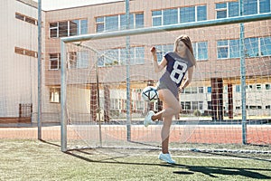 Beautiful girl with ball on the soccer field