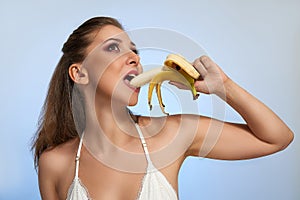 Beautiful girl with banana in studio, isolated. Food, fashion, healthcare, cosmetics concept, space for text