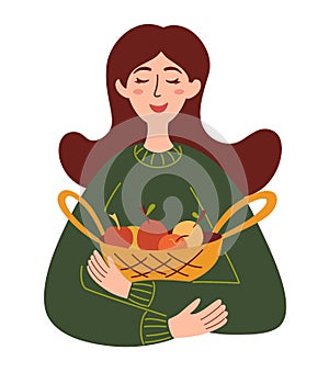 Beautiful girl with a basket of apples. Harvest season, healthy food, concept farm products. Girl farmer holds fruits in a basket