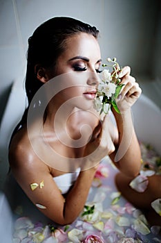 Beautiful girl in the bathroom with many flowers.