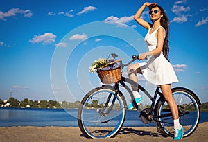 Beautiful girl on the beach with cruiser bicycle