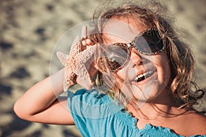 Beautiful girl at the beach with starfish