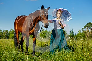 Beautiful girl in a beautiful dress standing next to the horse