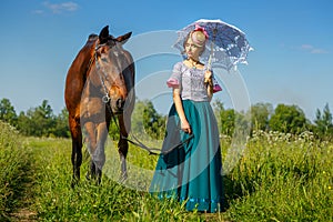 Beautiful girl in a beautiful dress standing next to the horse