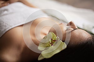 Beautiful girl in a beauty salon with orchid flower in her hair. spa treatments. close-up