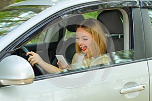 Beautiful girl behind the wheel of a car, looking phone smiling