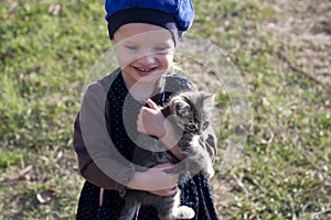 Beautiful girl in a beret with a gray kitten on his hands