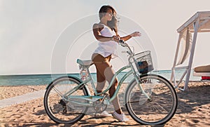 beautiful girl with a bicycle on the beach