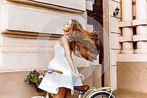 Beautiful girl on a bicycle near an ancient building