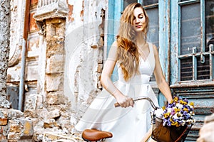 Beautiful girl with a bicycle near an old blue door