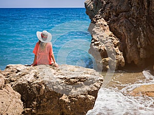 Beautiful girl in a bikini, hat and tunic sunbathing