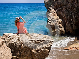 Beautiful girl in a bikini, hat and tunic sunbathing