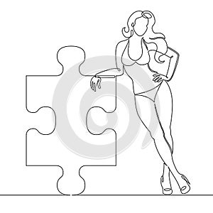 Beautiful girl in a bikini is holding a puzzle element in her hands.